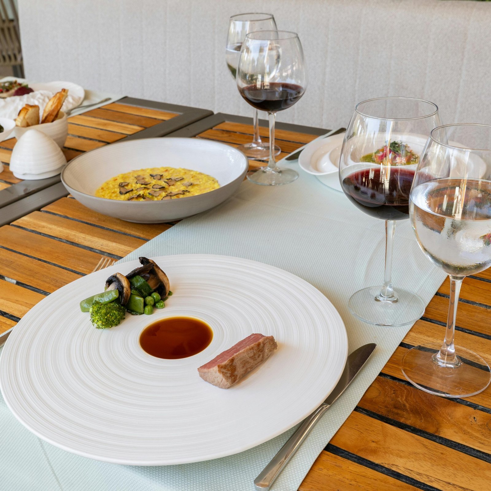 Elegant fine dining setup with gourmet dishes and red wine in Bodrum, Turkey.