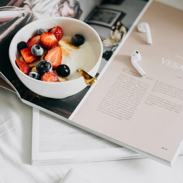 Fresh berries and yogurt bowl on a magazine, a perfect healthy breakfast.
